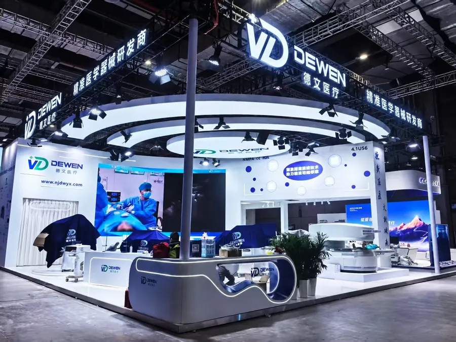 Curved overhead lighting above a white exhibition stand